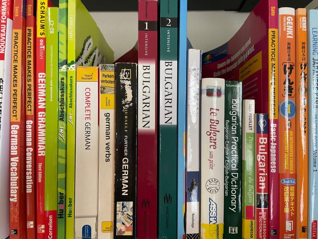 A line of textbooks on a bookshelf
